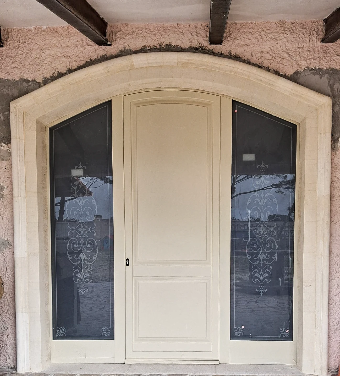 Portone chiaro ad arco con vetrate laterali decorate