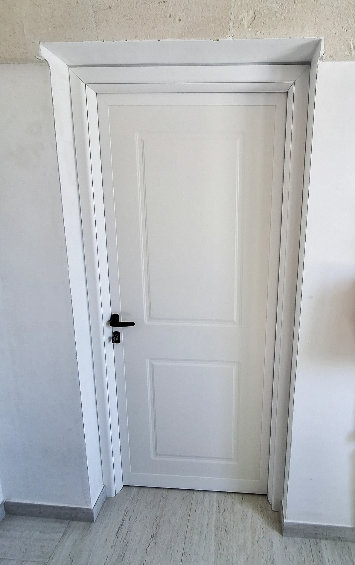 Porta interna bianca con pannelli e maniglia nera