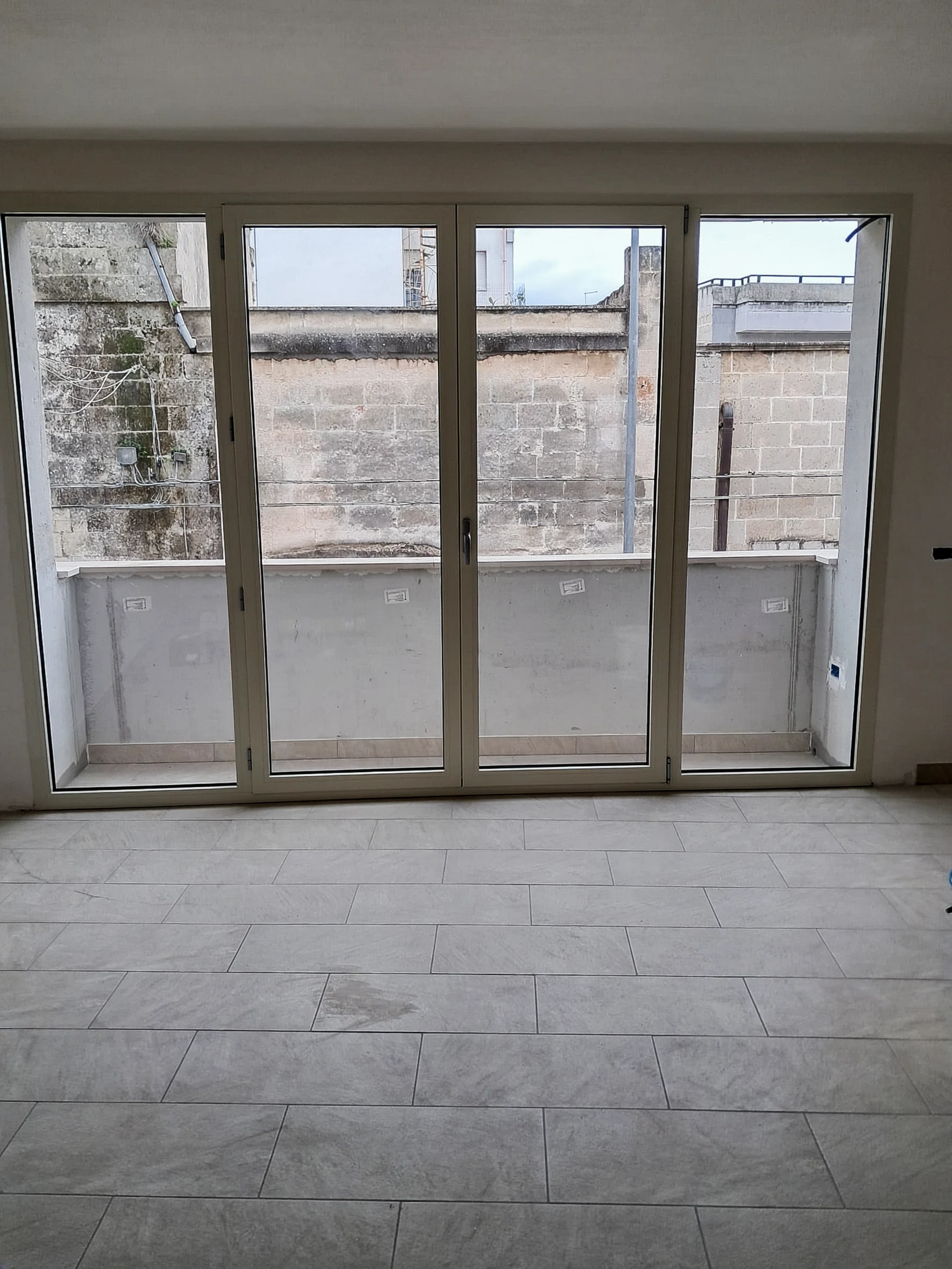 Ampia vetrata a quattro pannelli affacciata sul balcone